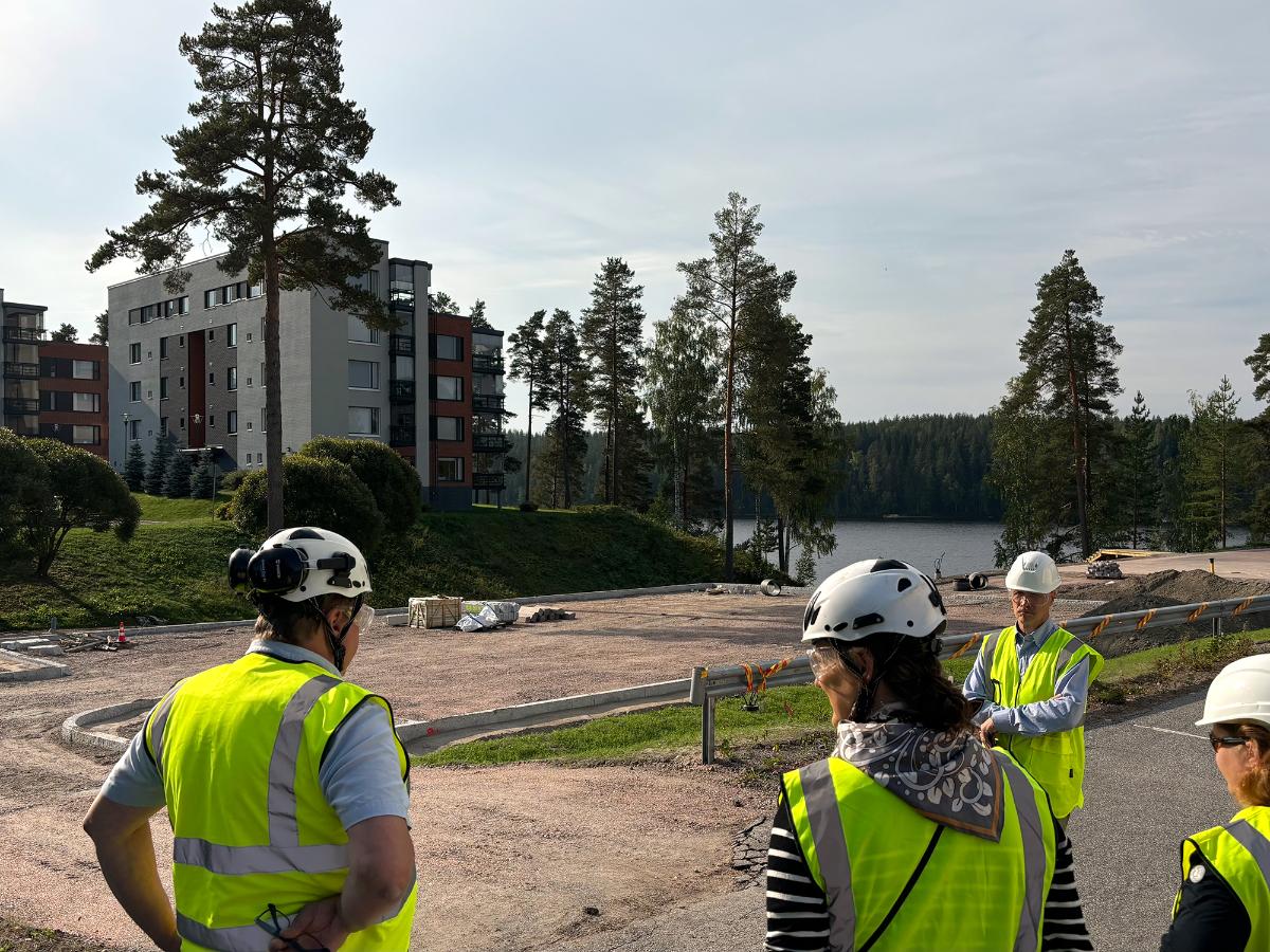 Yleiskuva Ruokolahden Rasilanrannasta. Etualalla ihmisiä työmaasuojavarusteissa.