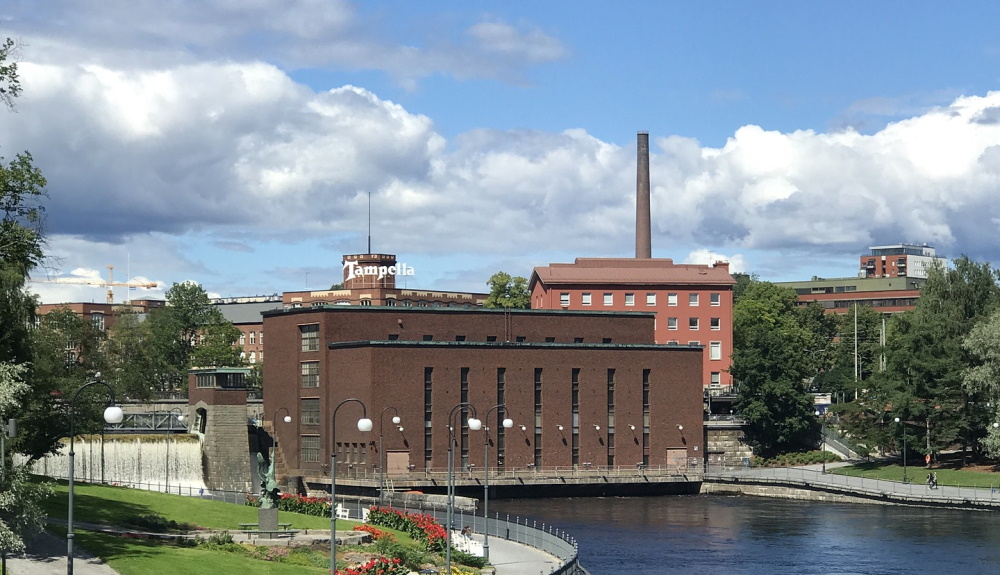 Tampereen Tammerkoski kesäaikaan, taustalla vanhaa tehdasaluetta.